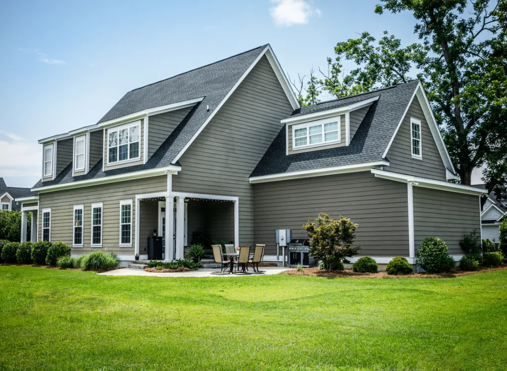 A large gray home with an ADU (Accessory Dwelling Unit) home addition attached to the side of it.